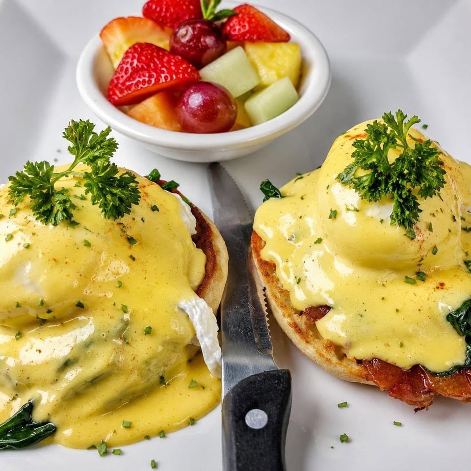 Eggs Benedict with hollandaise sauce and fruit